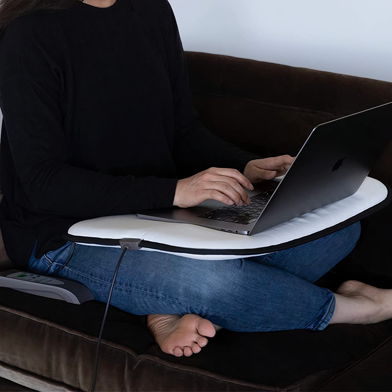 girl working on her laptop ontop of an omi mini mat pemf machine in the uk