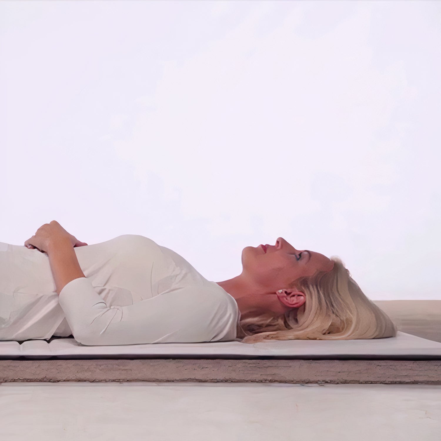 a girl laying down on a pemf therapy mat in the uk looking up a the sky