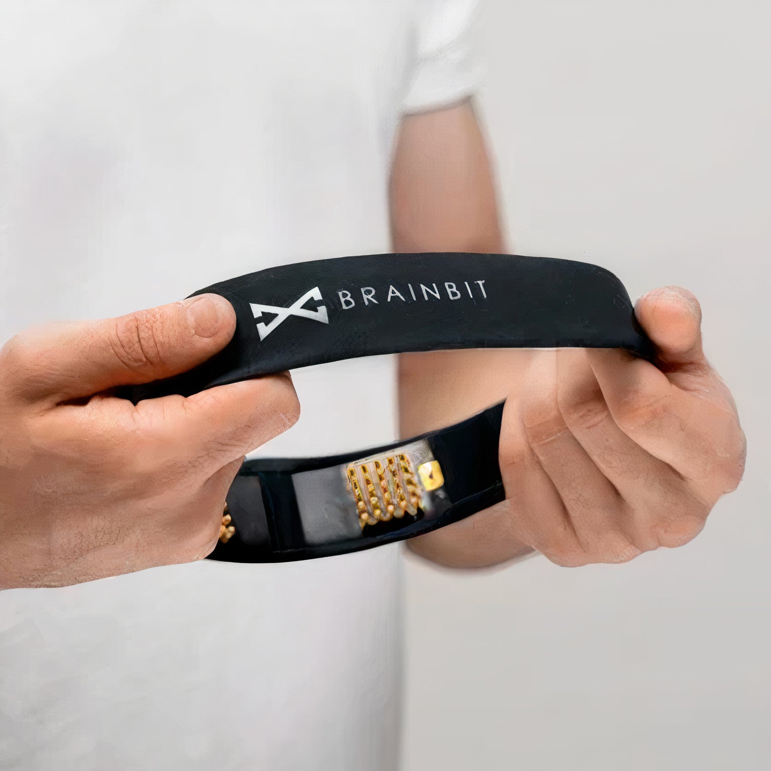 man holding a brainbit headband with two hands