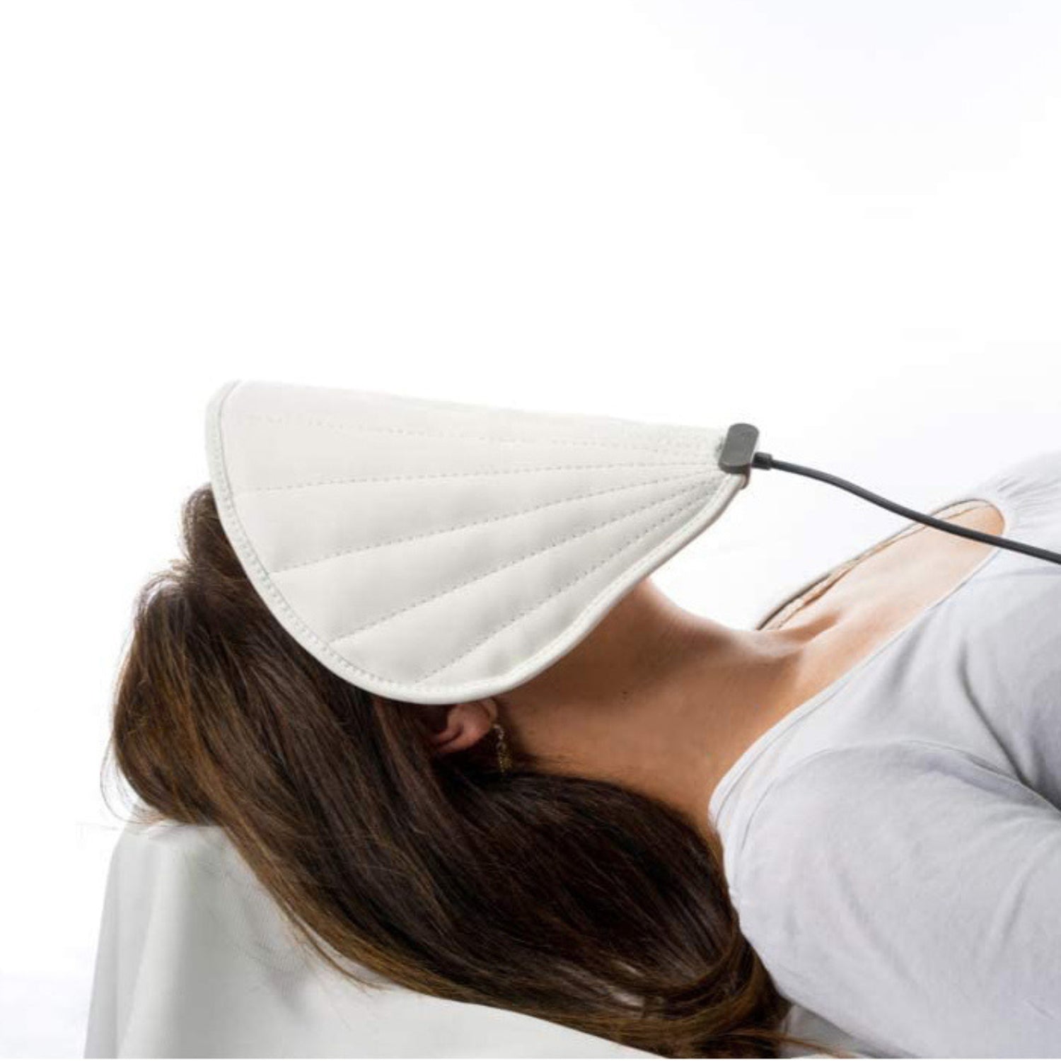 a girl laying down with a pemf shell mask on her face