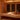 Warm wooden home infrared sauna with a towel, water bucket and carafe on the bench
