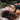 A girl laying on a mat outside in nature surrounded by grass and leaves, showing the effects of grounding therapy.
