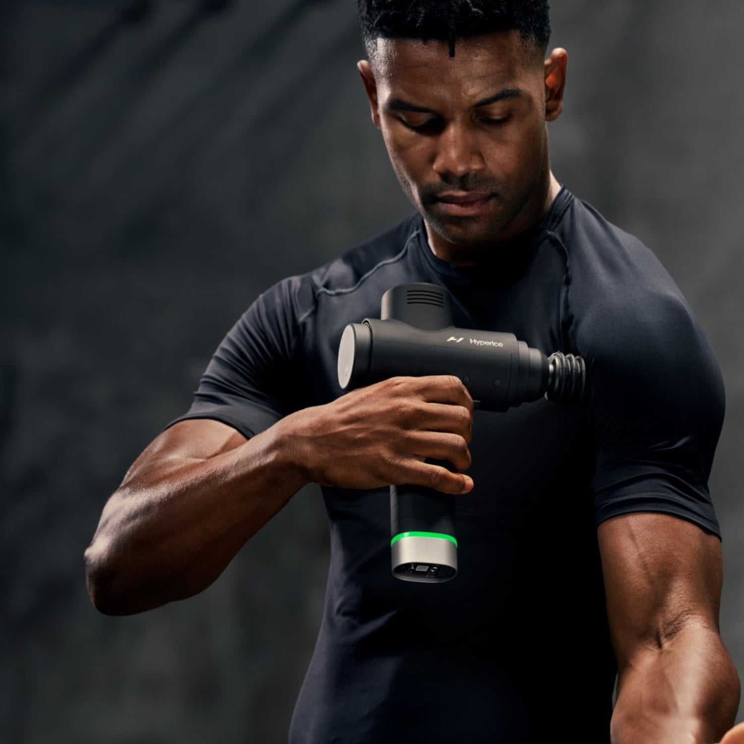 a man with a black backdrop with a small shine using a percussion gun on his shoulder